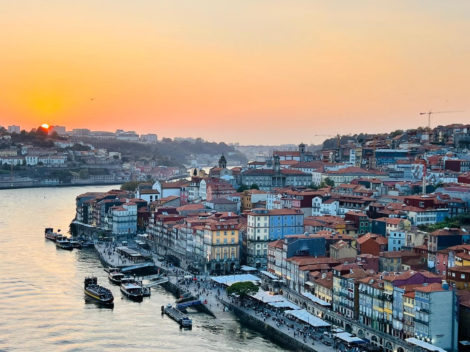 Golden sunset over the Douro River and colorful historic buildings of Porto, Portugal.